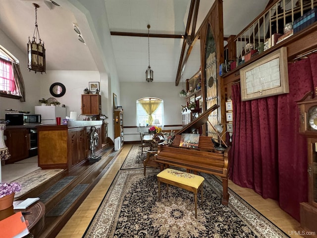 miscellaneous room with vaulted ceiling with beams and wood-type flooring