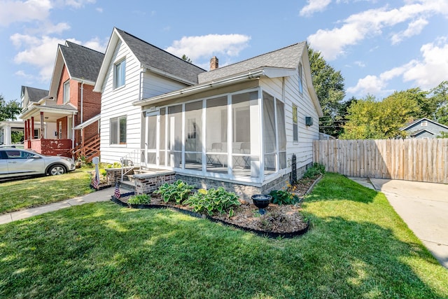 view of front facade featuring a front yard and a sunroom