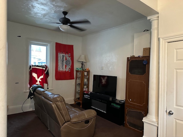 living room with ornate columns, ceiling fan, and carpet floors