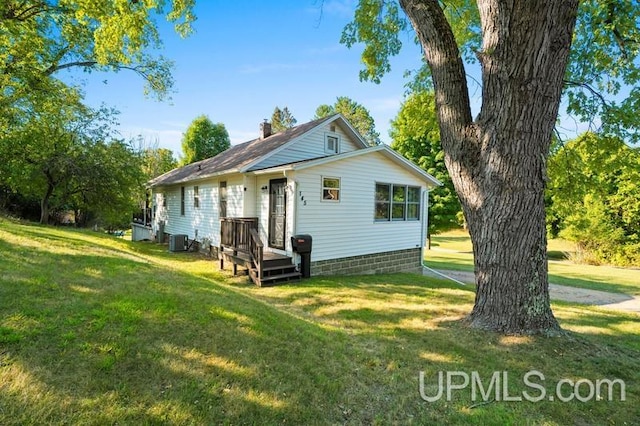 back of property featuring a lawn and central AC unit