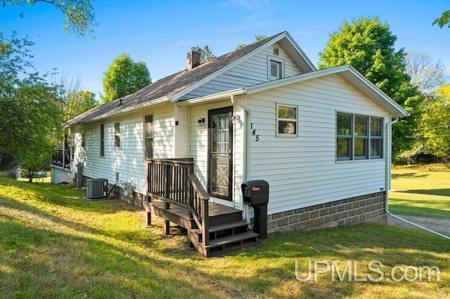 exterior space featuring a yard and central AC