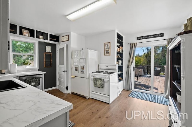 kitchen featuring plenty of natural light, wood-type flooring, and white appliances