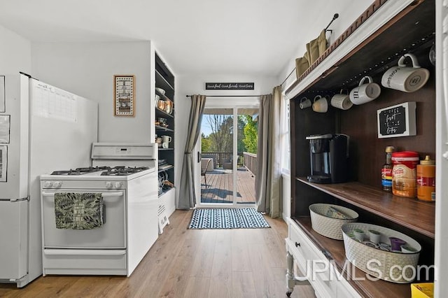 kitchen with light hardwood / wood-style flooring and gas range gas stove