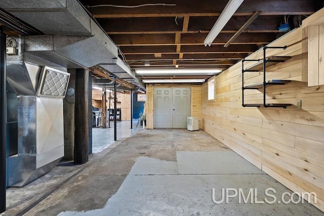 basement featuring wood walls