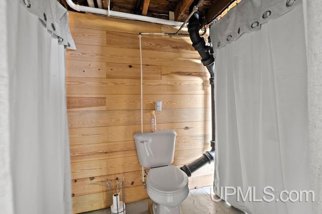 interior space featuring wood walls and toilet