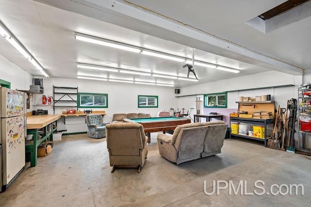 garage with a workshop area and white fridge