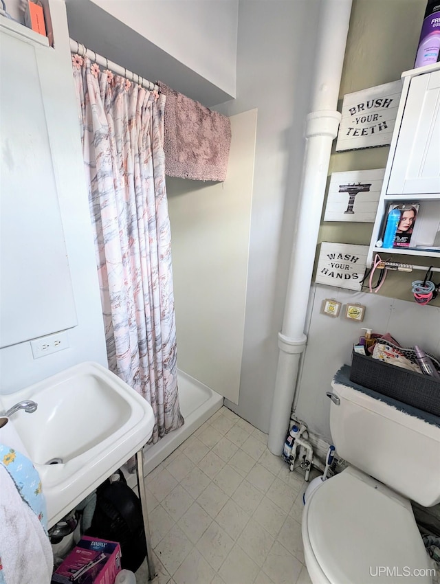 bathroom featuring toilet and a shower with curtain