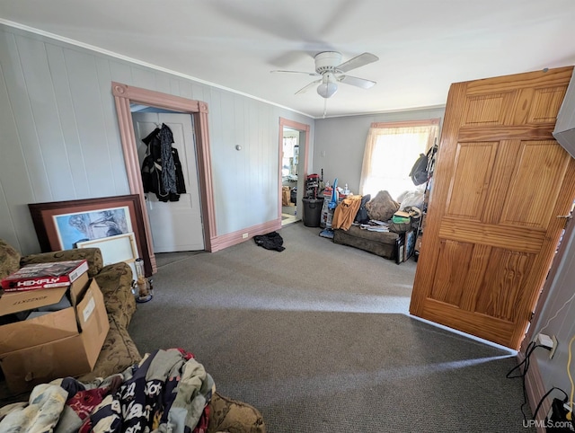 interior space featuring ornamental molding, ceiling fan, and carpet floors