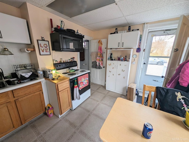510-512 W Bluff St, Marquette, MI 49855 - kitchen with white electric stove, black microwave, a paneled ceiling, light countertops, and backsplash