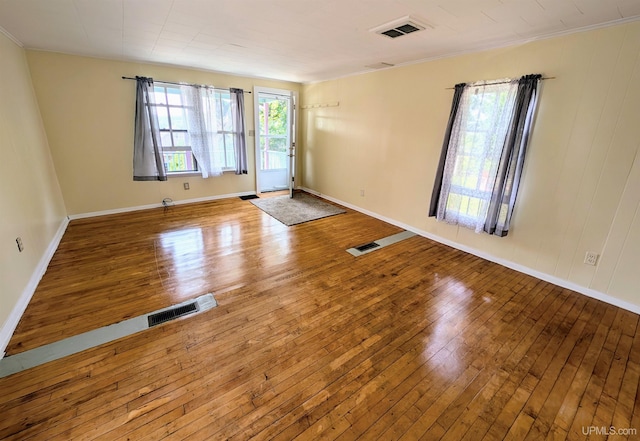 spare room featuring wood-type flooring and ornamental molding