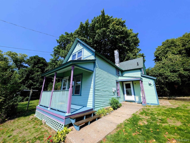 view of front facade with a front yard and covered porch