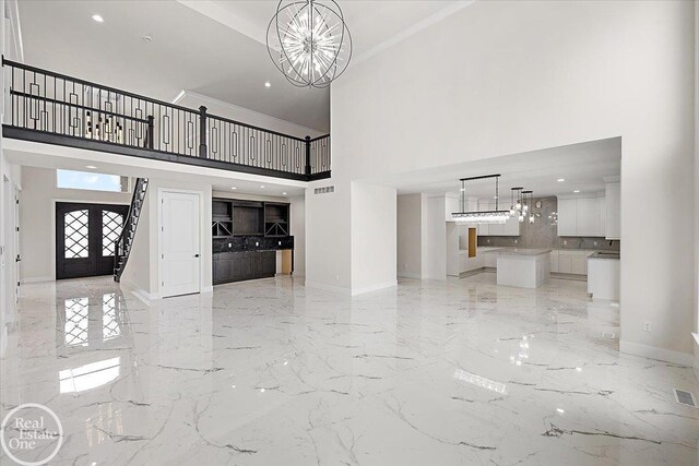 kitchen with light brown cabinets, decorative light fixtures, an inviting chandelier, fridge with ice dispenser, and a kitchen island