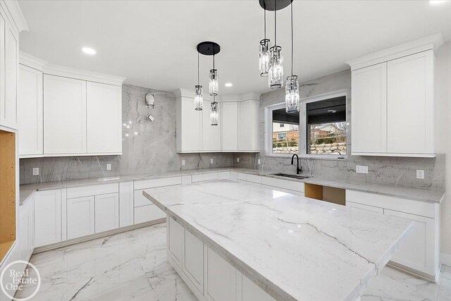 kitchen with a sink, decorative backsplash, marble finish floor, and white cabinetry