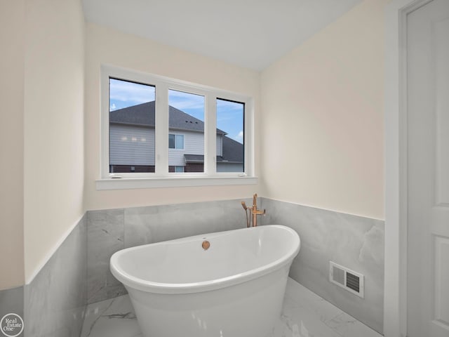 bathroom with a bath and tile walls