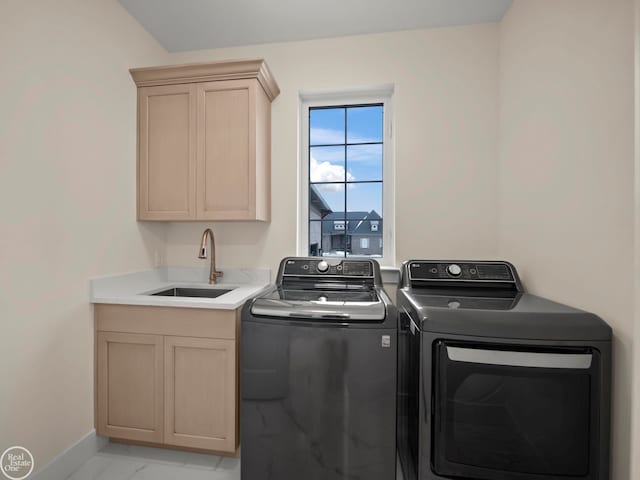 laundry area with cabinets, independent washer and dryer, and sink