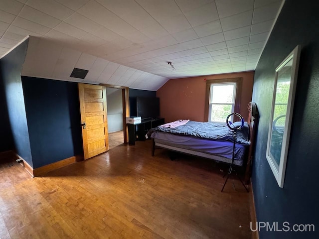 bedroom featuring lofted ceiling and wood-type flooring