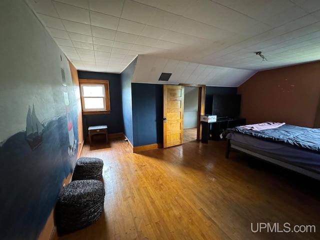 bedroom with lofted ceiling and hardwood / wood-style floors