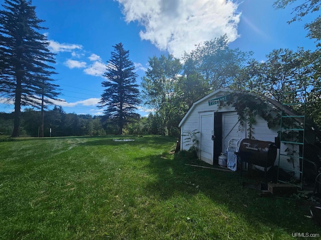 view of yard featuring a garage and an outdoor structure