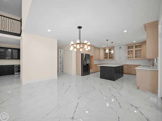 kitchen with light brown cabinets, a notable chandelier, fridge with ice dispenser, a center island, and hanging light fixtures