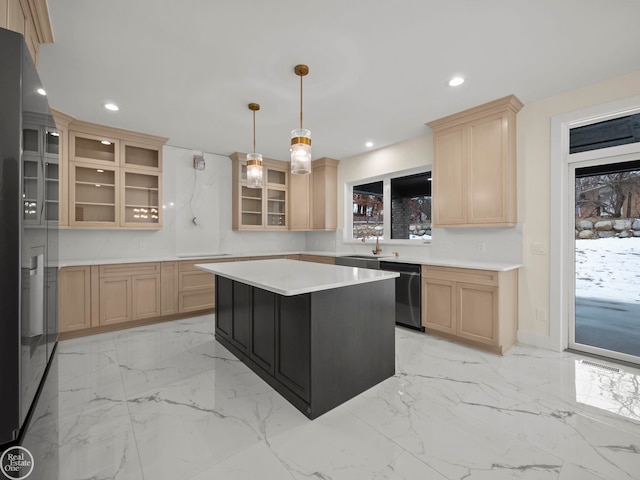 kitchen with light brown cabinetry, stainless steel appliances, sink, decorative light fixtures, and a center island