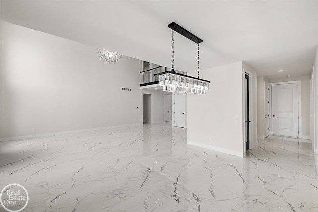 empty room with baseboards, marble finish floor, and an inviting chandelier