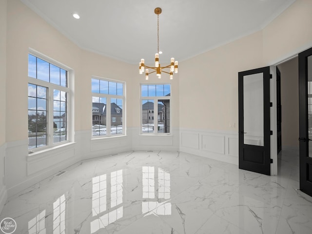 unfurnished dining area with an inviting chandelier and crown molding