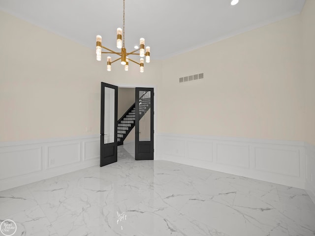 empty room with crown molding and a notable chandelier