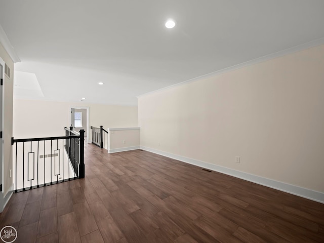 empty room with crown molding and dark hardwood / wood-style floors