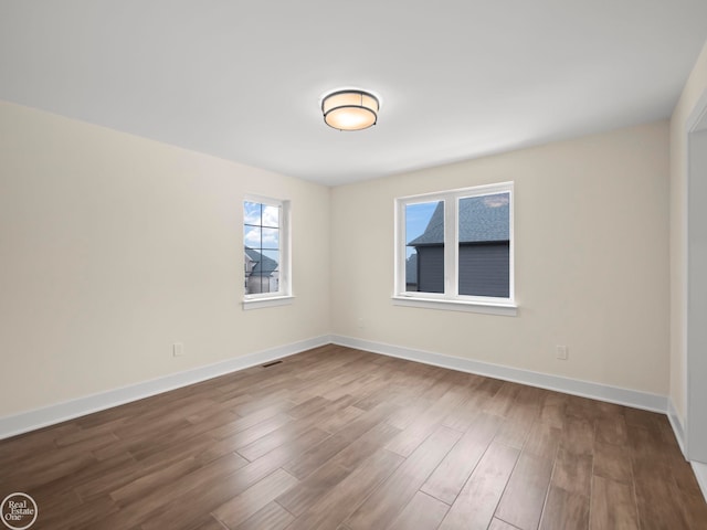 unfurnished room with hardwood / wood-style flooring