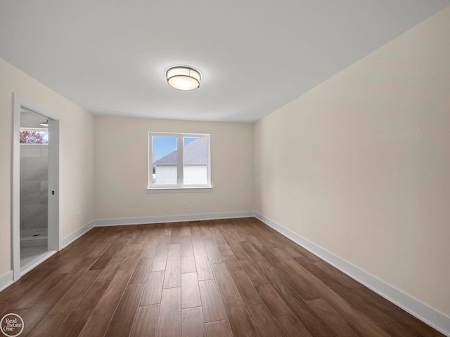 unfurnished room with dark wood-type flooring