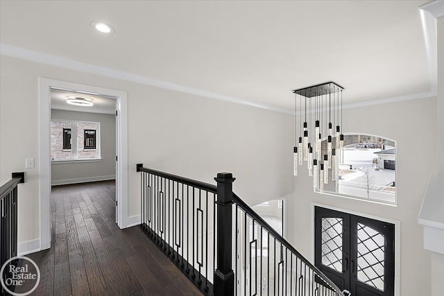 hall featuring baseboards, french doors, hardwood / wood-style flooring, crown molding, and an upstairs landing