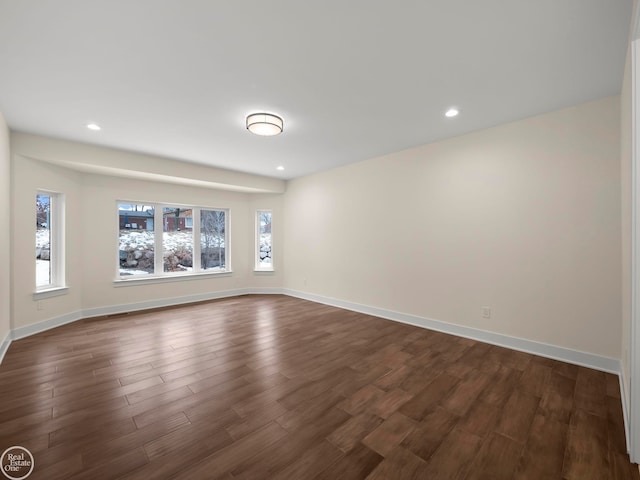 unfurnished room with dark hardwood / wood-style flooring and a wealth of natural light