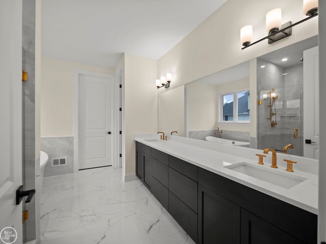 bathroom with vanity and shower with separate bathtub