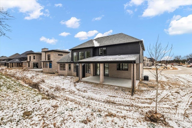 snow covered property with a patio