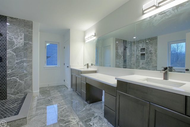 full bath featuring vanity, baseboards, marble finish floor, and walk in shower