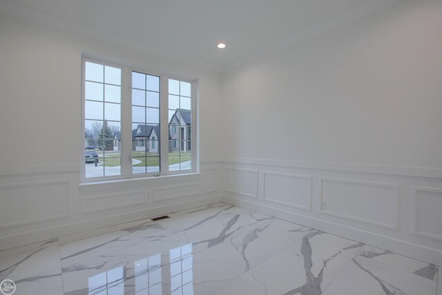 spare room with visible vents, marble finish floor, recessed lighting, wainscoting, and a decorative wall