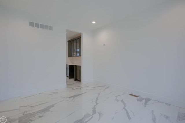 empty room featuring visible vents, recessed lighting, marble finish floor, and baseboards