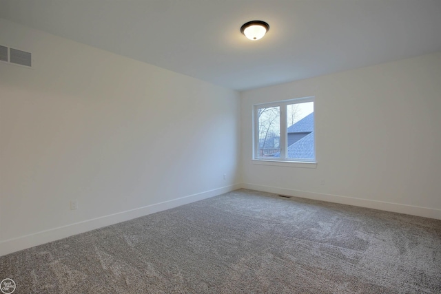 carpeted empty room with visible vents and baseboards