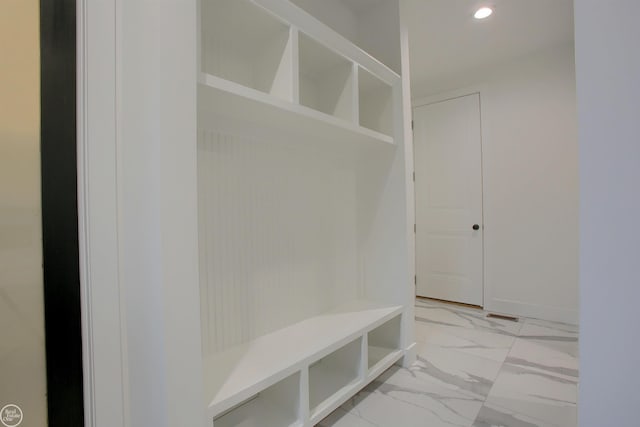 mudroom featuring recessed lighting, marble finish floor, and baseboards