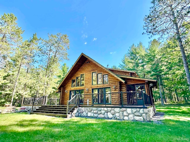 back of property with a yard and a wooden deck