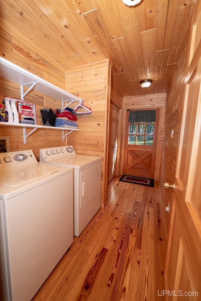 washroom with independent washer and dryer, wooden walls, wooden ceiling, and light hardwood / wood-style floors