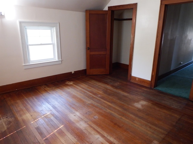 unfurnished bedroom with dark hardwood / wood-style floors and a closet