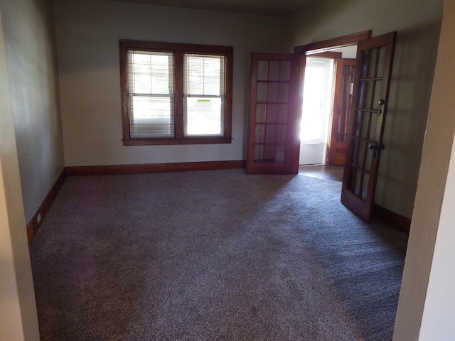 carpeted spare room featuring french doors