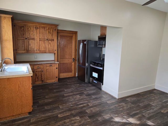 kitchen with ceiling fan, sink, appliances with stainless steel finishes, and dark wood-type flooring