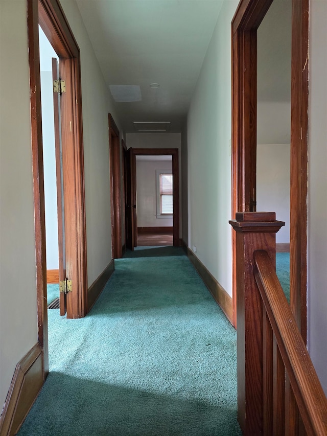 hall with dark colored carpet