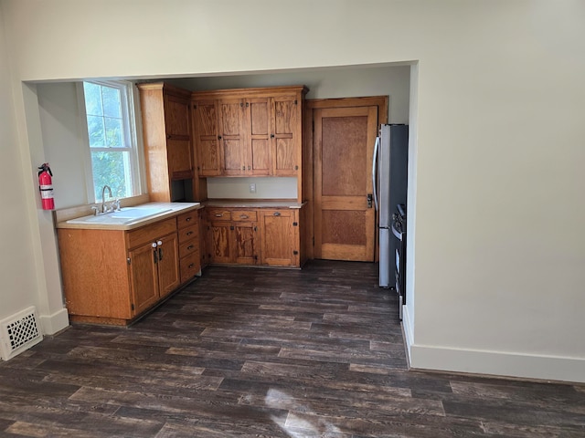 kitchen with sink, dark hardwood / wood-style flooring, and stainless steel refrigerator