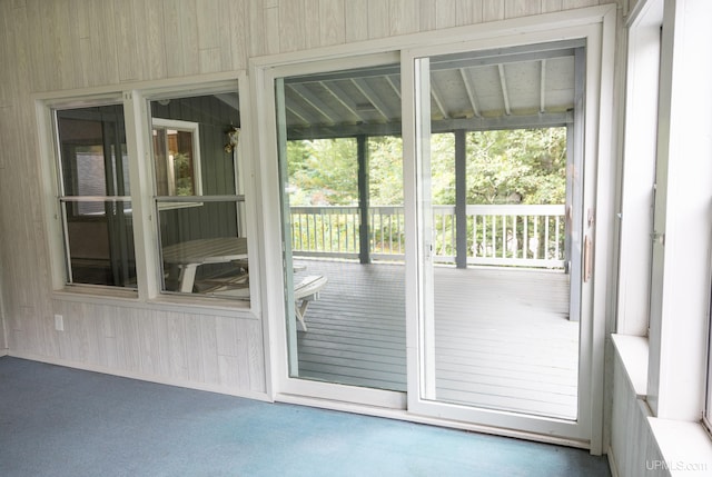 doorway to outside featuring wood walls