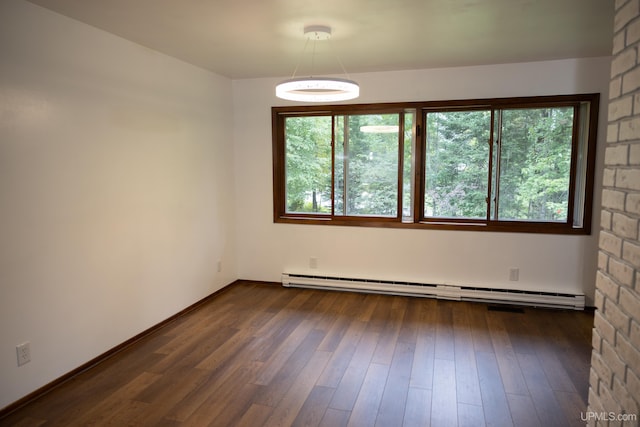 spare room featuring a baseboard radiator and dark wood-type flooring