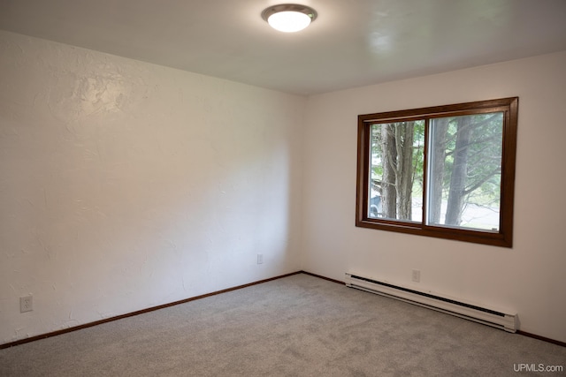 spare room with baseboard heating and carpet