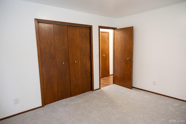 unfurnished bedroom with a closet and light carpet